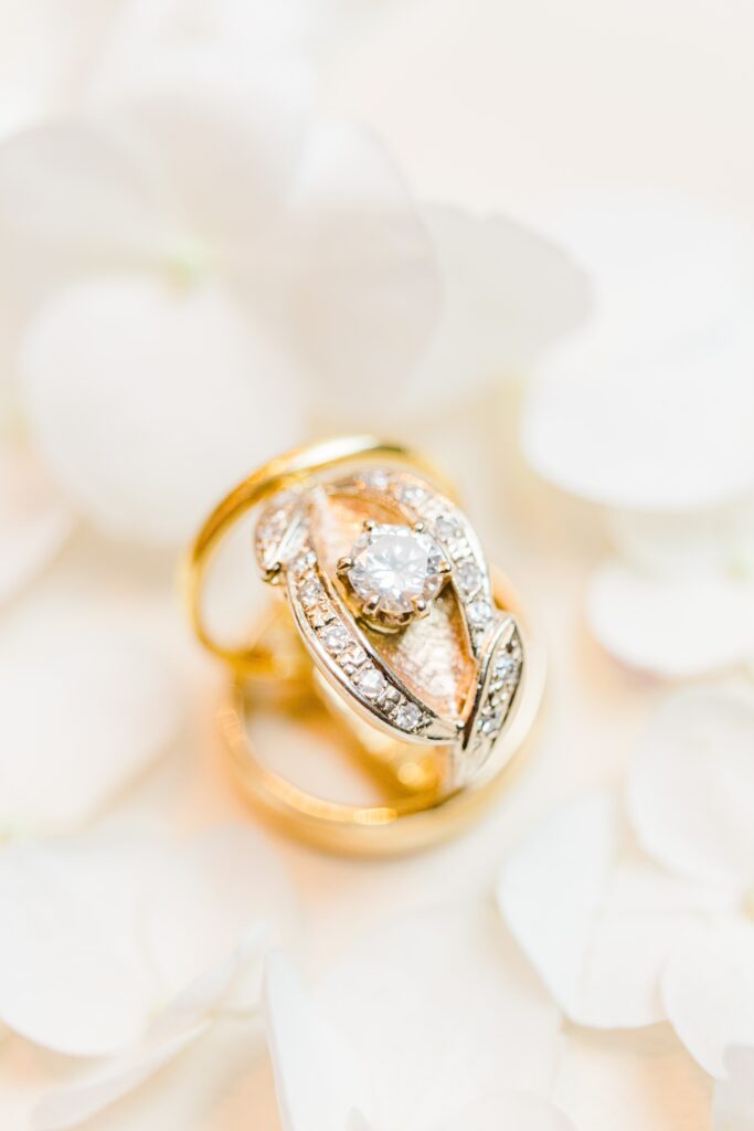 close up of wedding rings with white hydrangeas 