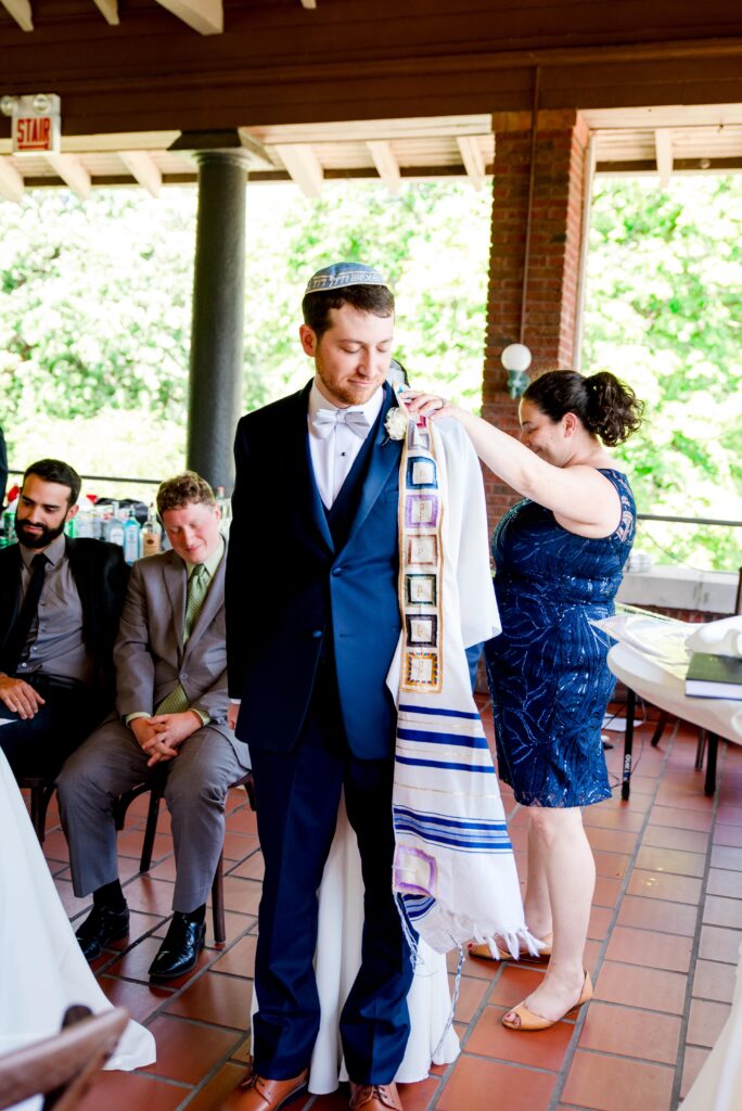 bride and groom standing back to back with eyes closed during part of a Jewish wedding tradition at Cafe Brauer