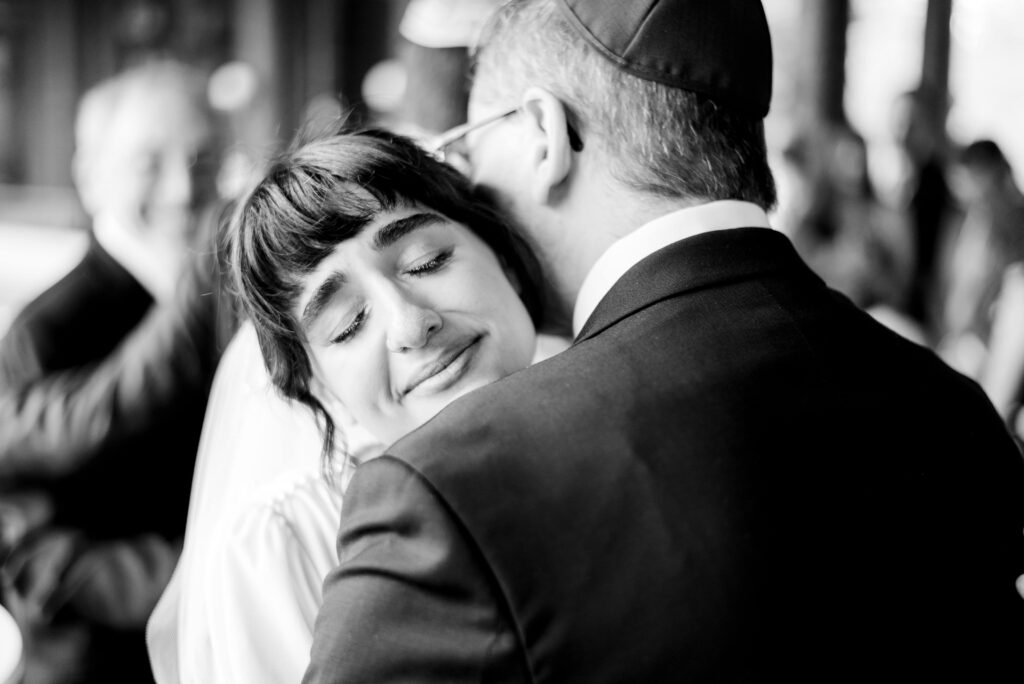 bride smiling with eyes closed while hugging a man 
