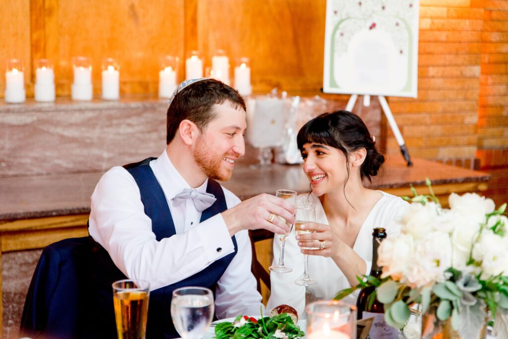 couple smiling at each other and clinking champagne glasses 