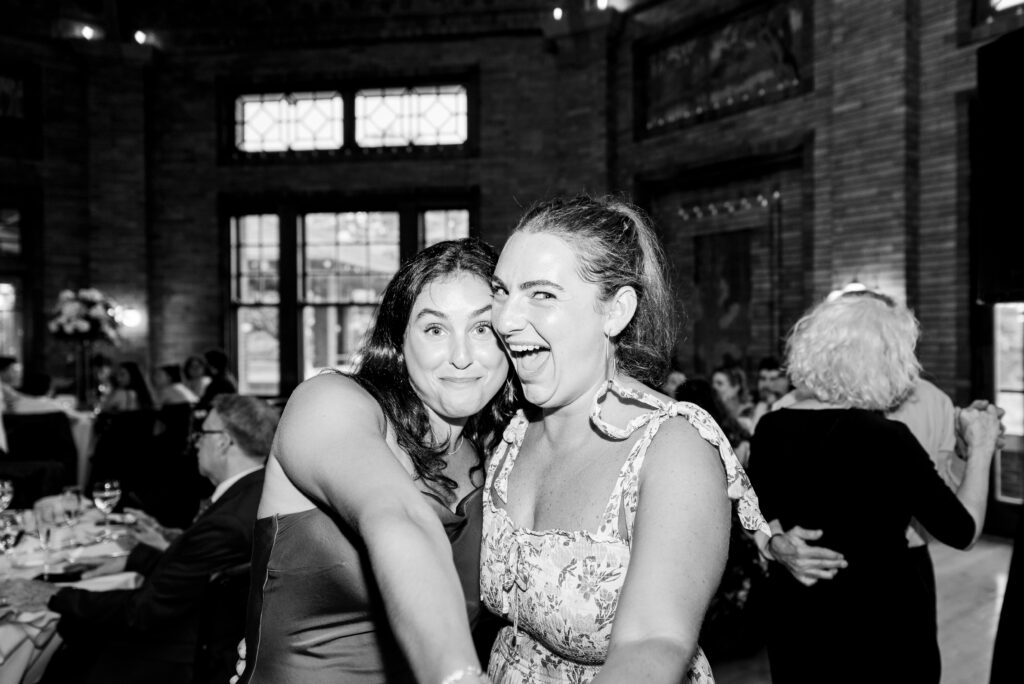 two friends smile at the camera at Cafe Brauer wedding