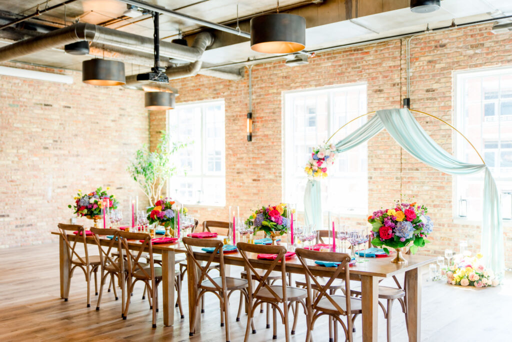long table with colorful flowers set up at a wedding at Loft Lucia