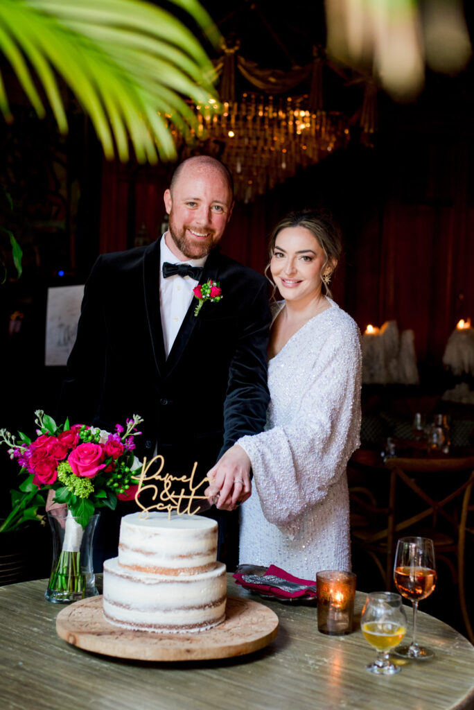 couple smiling with their wedding cake at beatnik west town