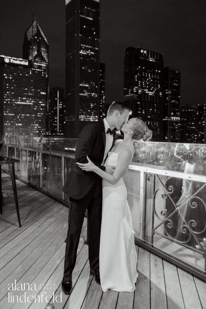 couples kisses on roof of University club of chicago at night