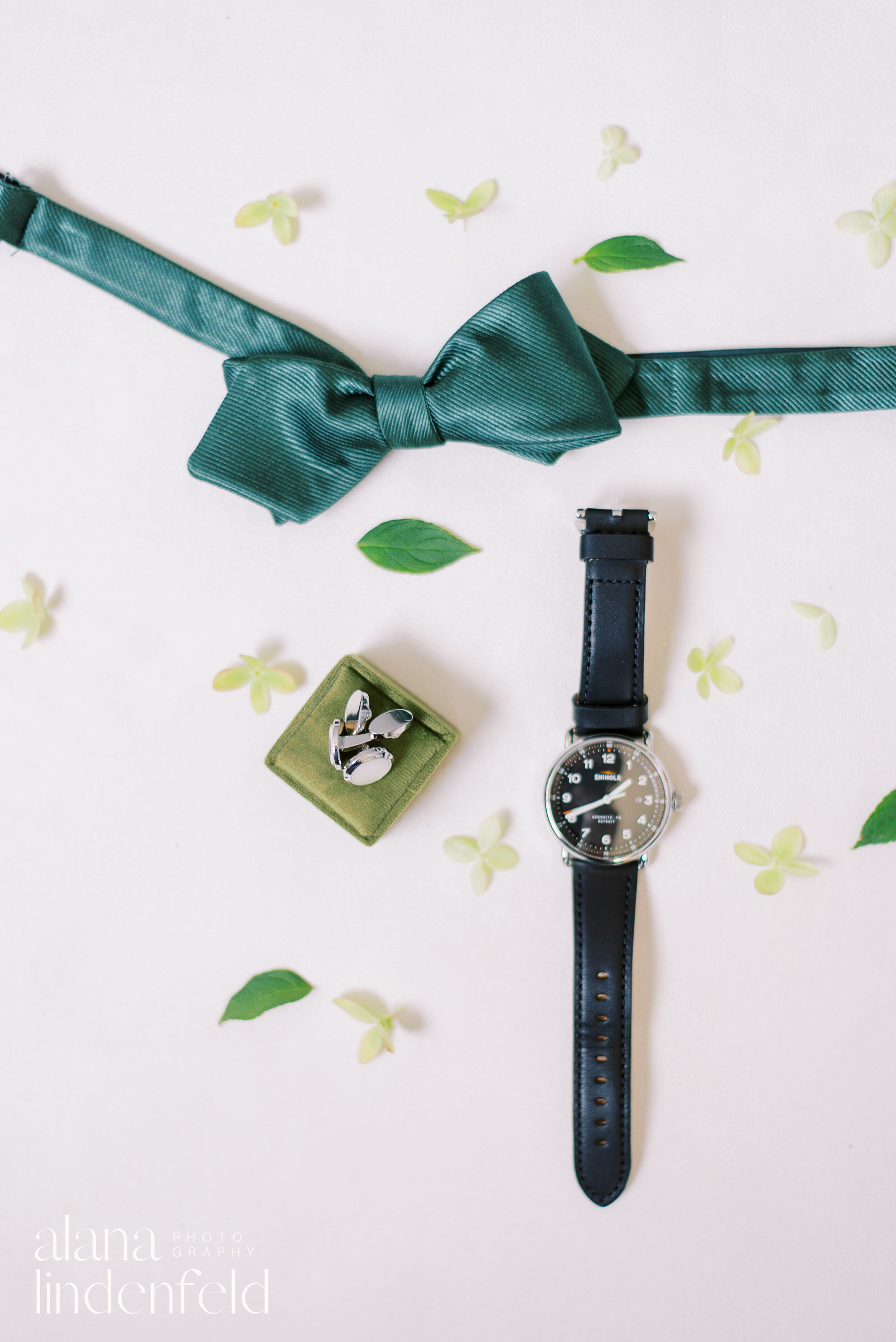 groom flat lay with green details