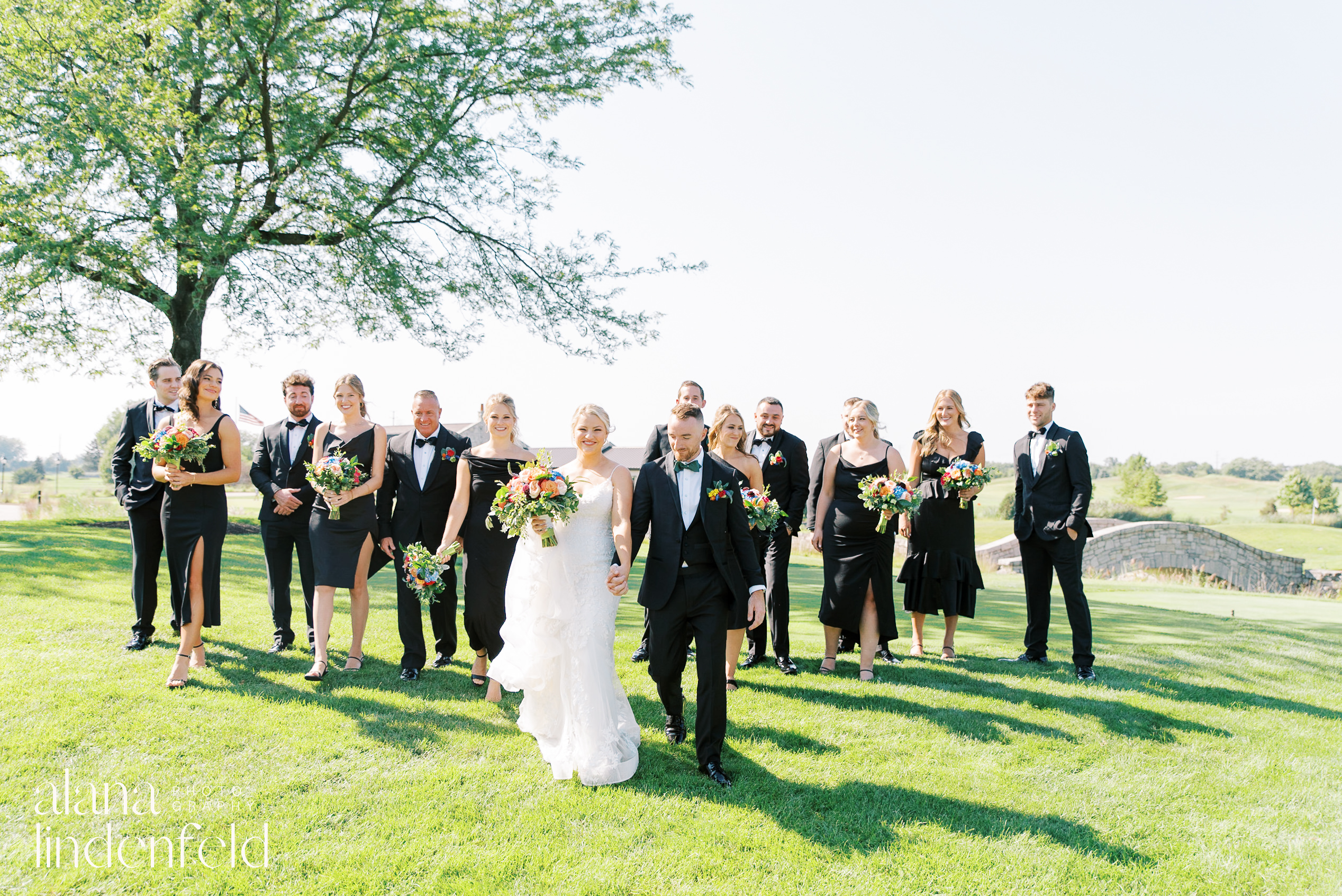 wedding party in all black with colorful flowers at Mistwood Golf Club