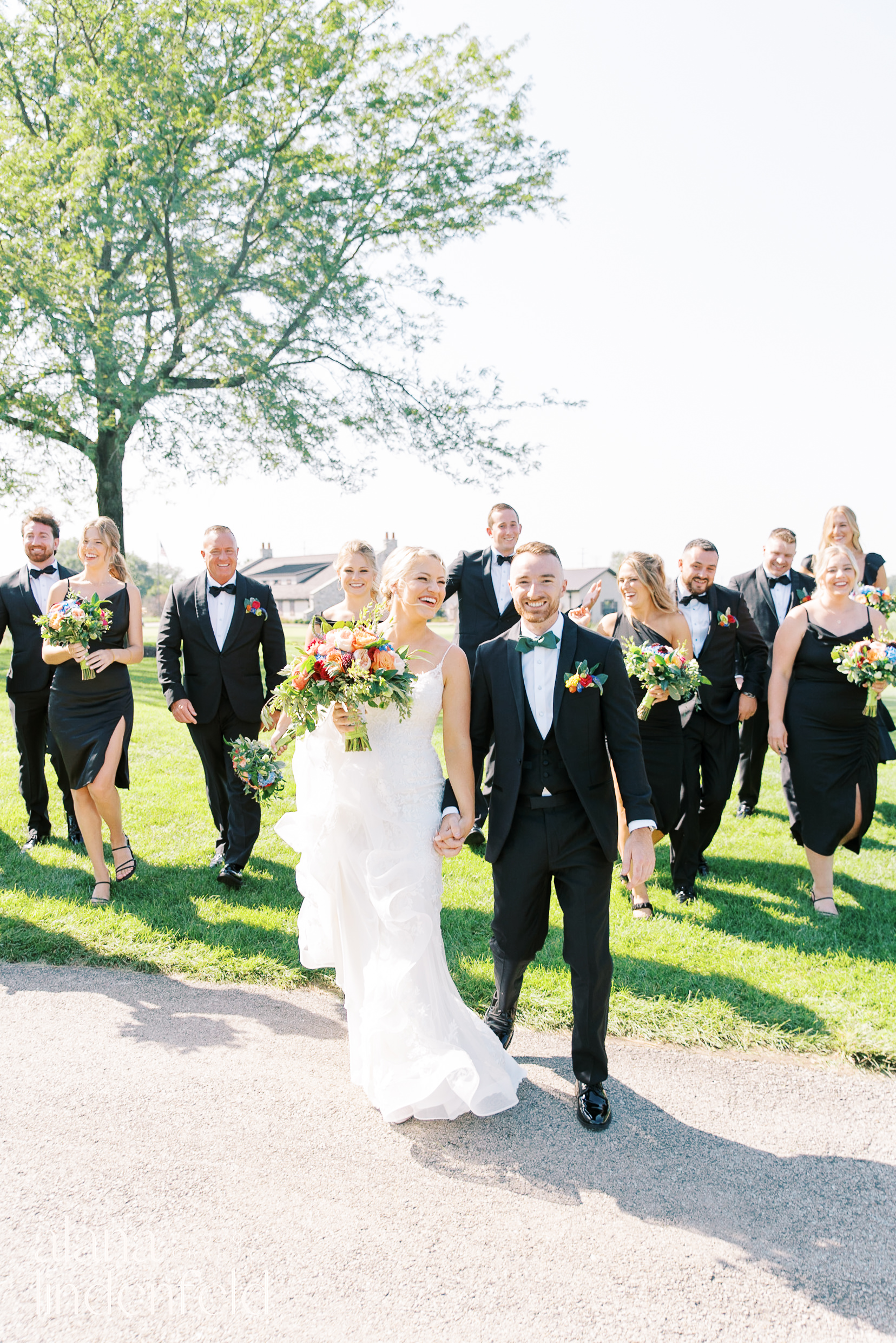 bridal party in all black with colorful flowers at Mistwood Golf Club summer wedding