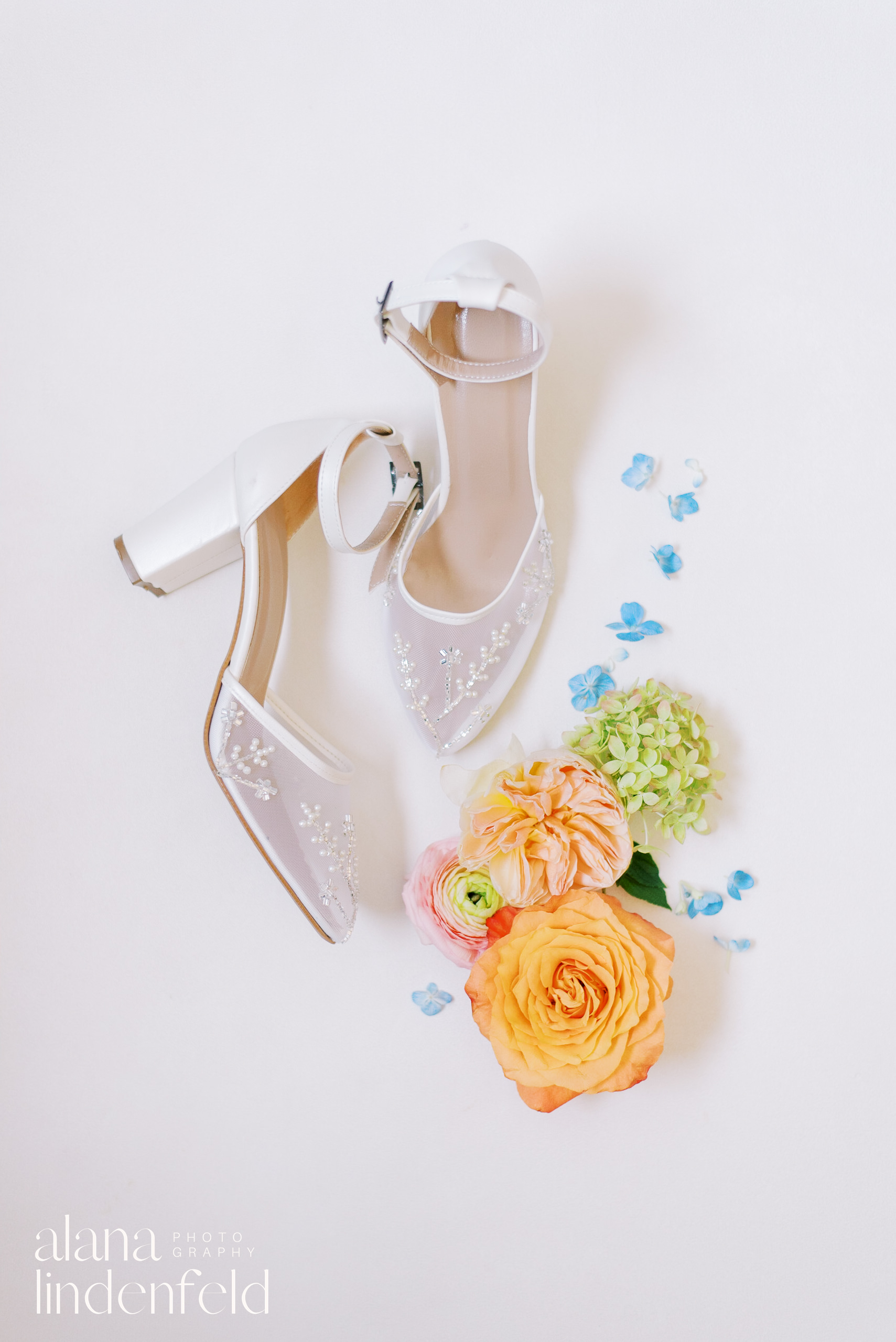 wedding shoe flat lay with multicolored flowers