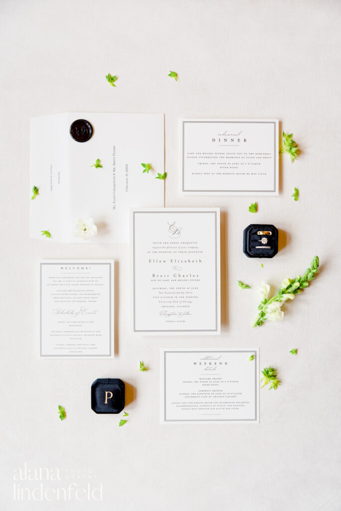 white and black wedding invite suite with black ring box and greenery