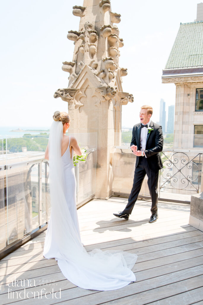 bride and groom smile at each other on roof of University Club of Chicago

