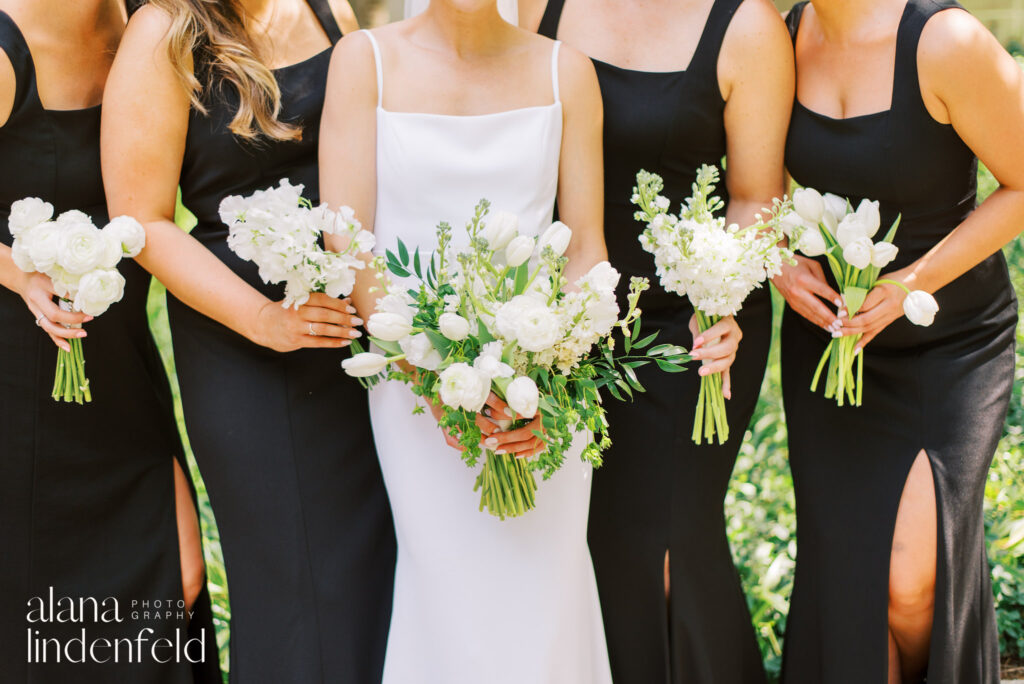 close up of bridal bouquet and bridesmaids in black, each holding a bouquet