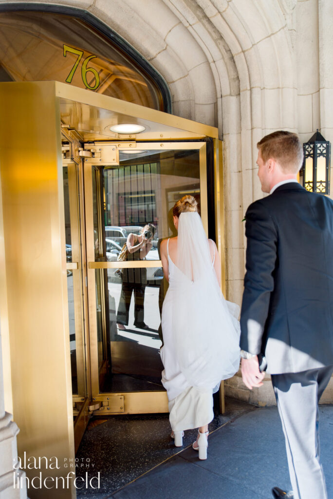 bride and groom enter revolving doors entrance to University Club of Chicago