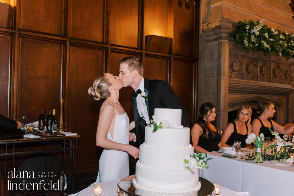 couple cuts white wedding cake at university club chicago wedding reception 