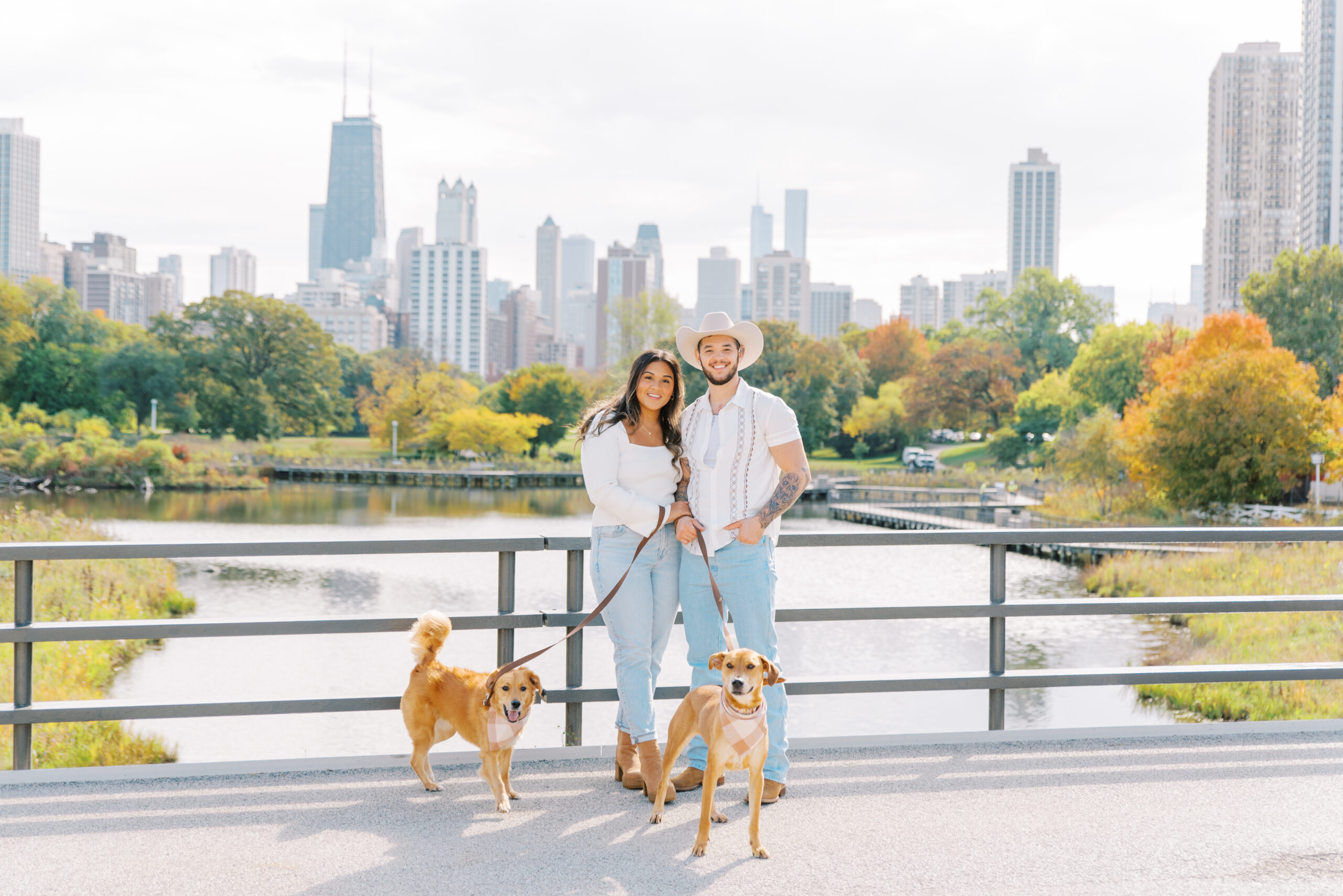 couple and dogs in front of fall foliage at lincoln park chicago engagement session