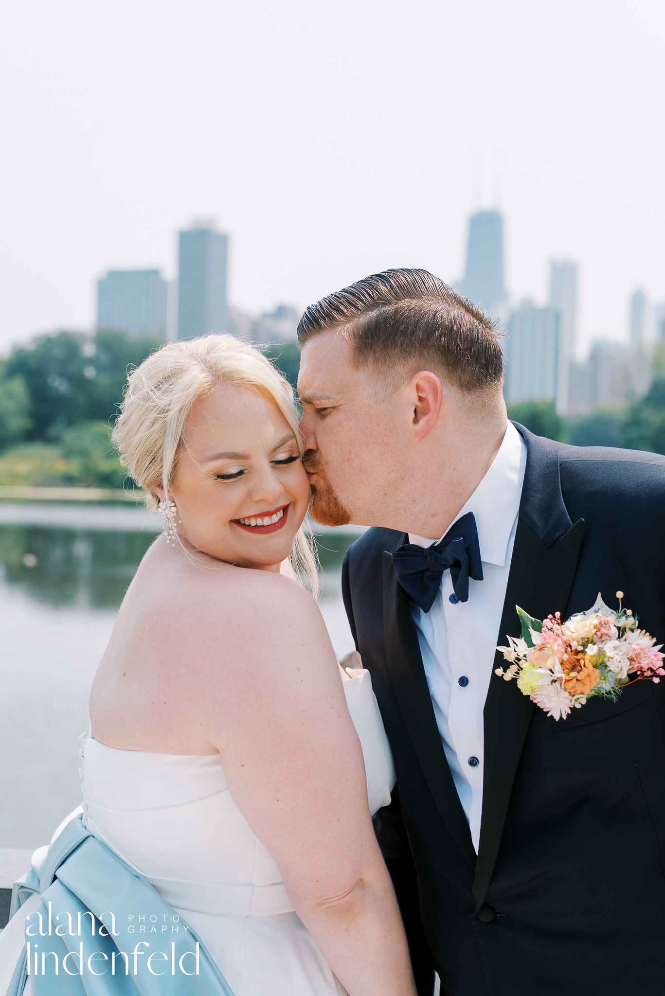 groom kissing bride on cheek 
