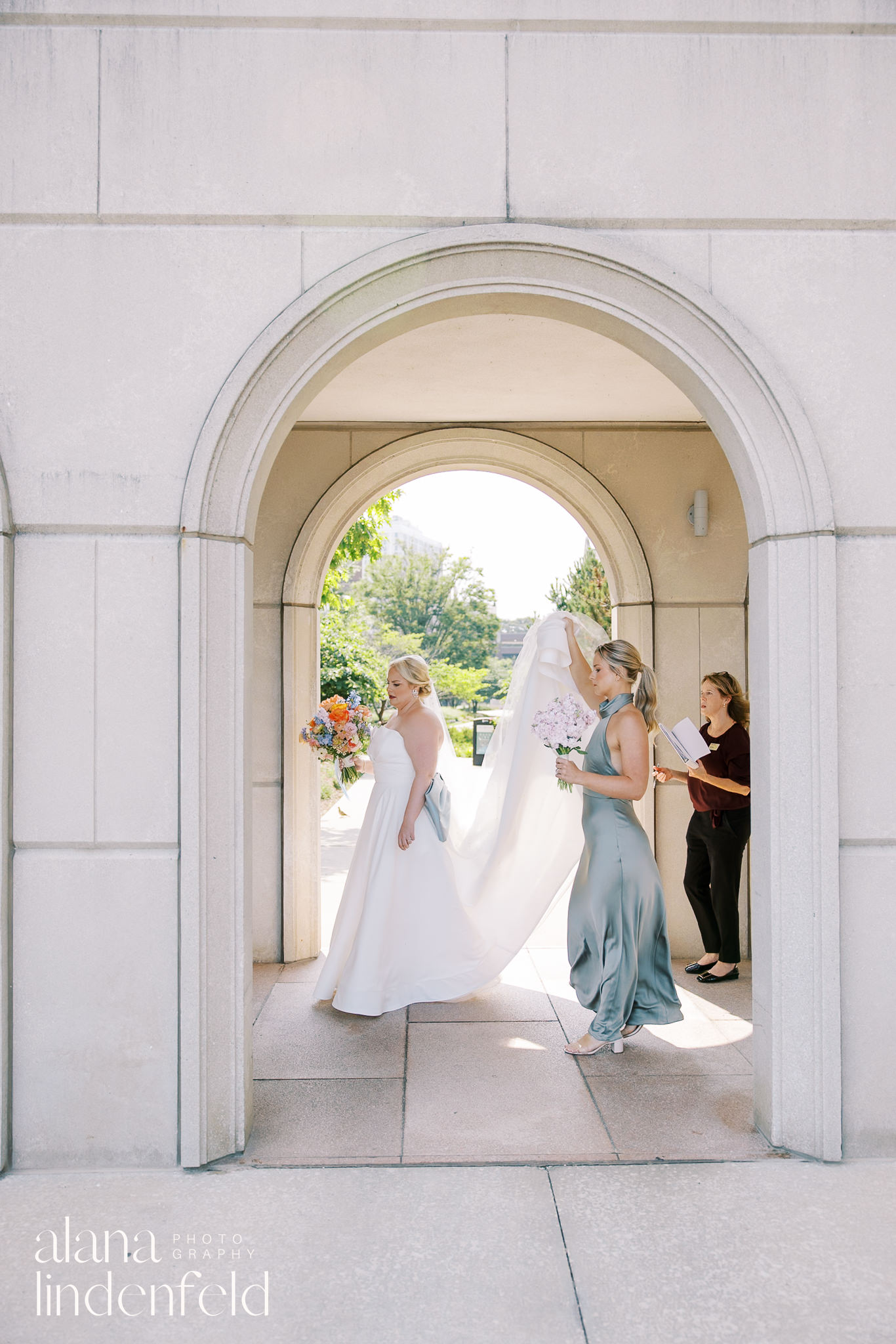 bride and bridesmaid walking through outdoor arches at Madonna Della Strada Church