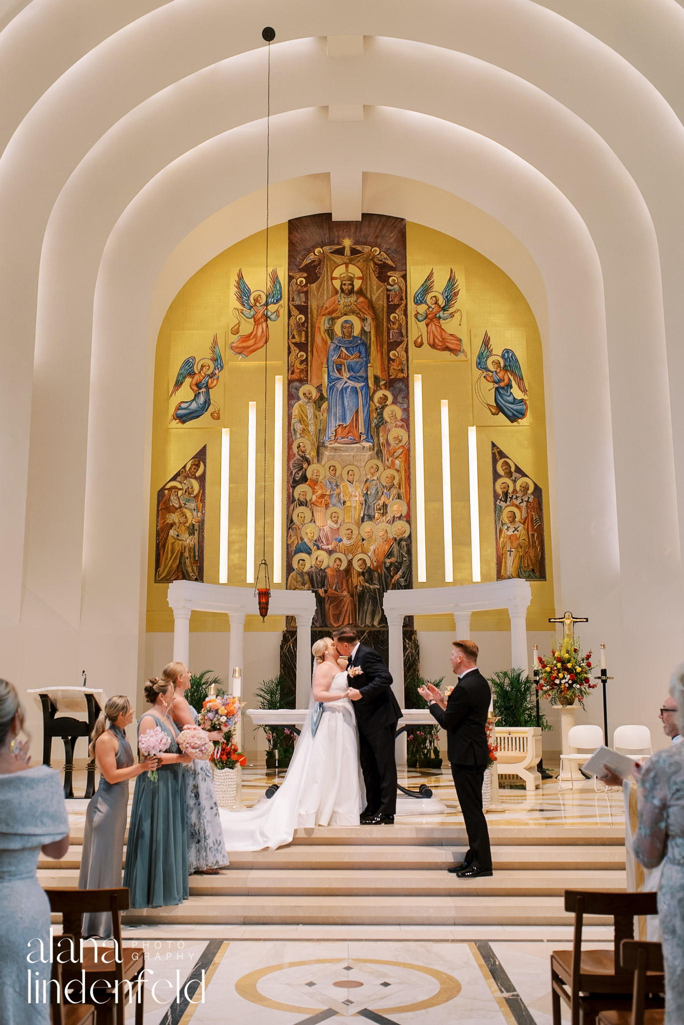 bride and groom kiss in church aisle at madonna della strada church