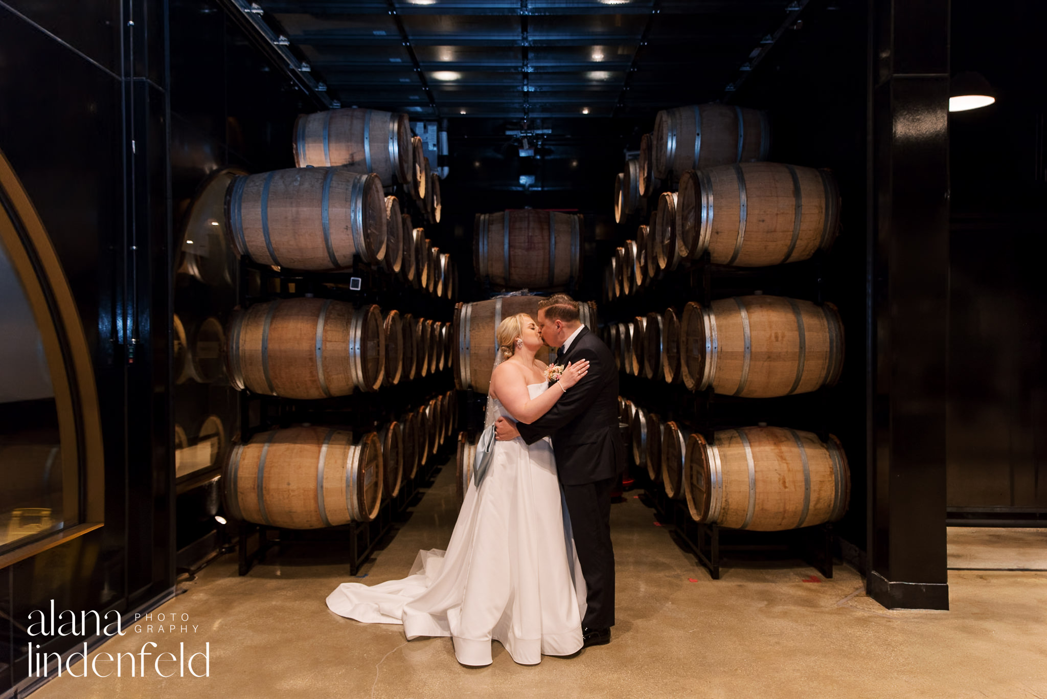 bride and groom kissing at chicago winery barrel room