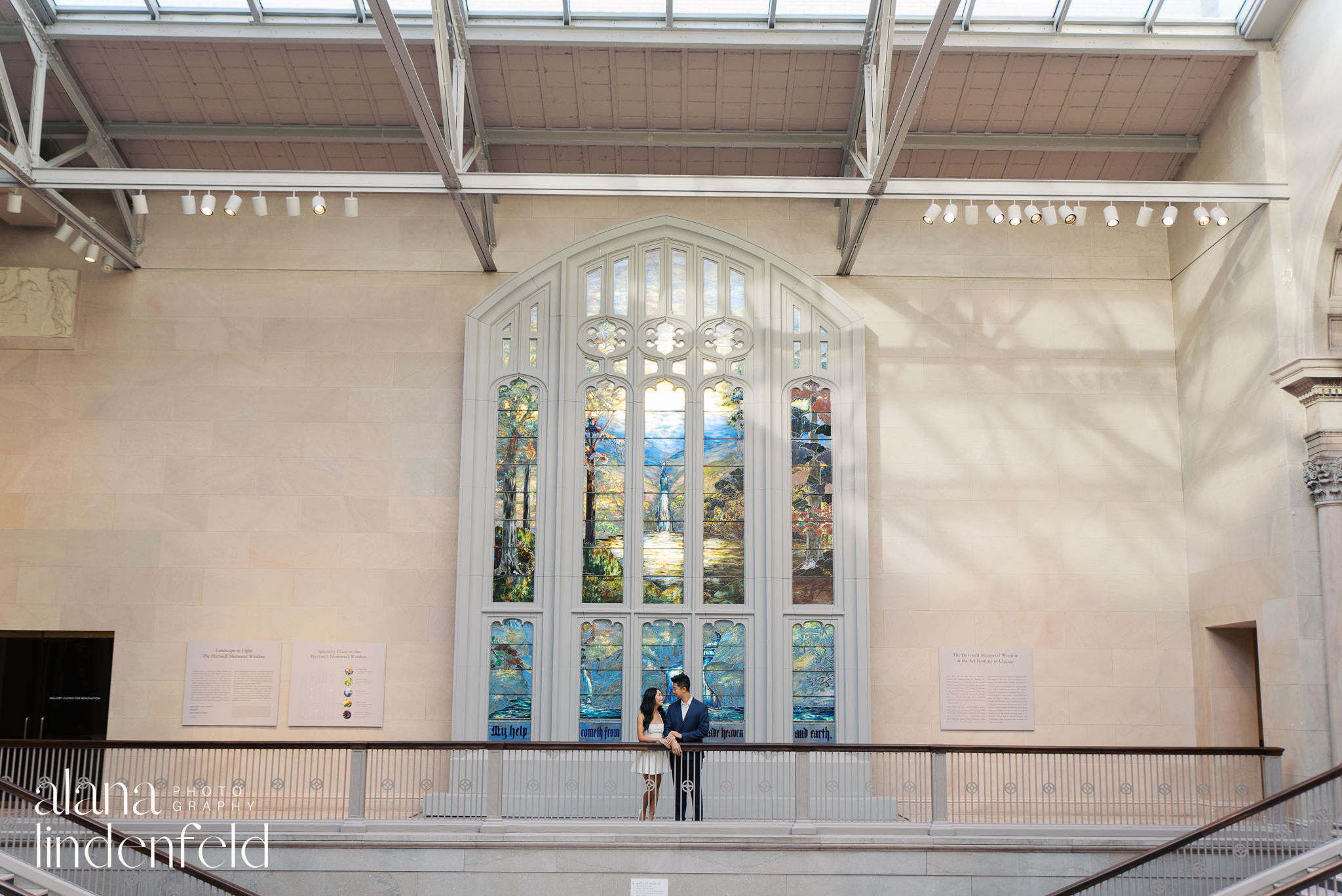 couple in white dress and navy suit at Art Institute of Chicago Proposal photos in front of Tiffany Window