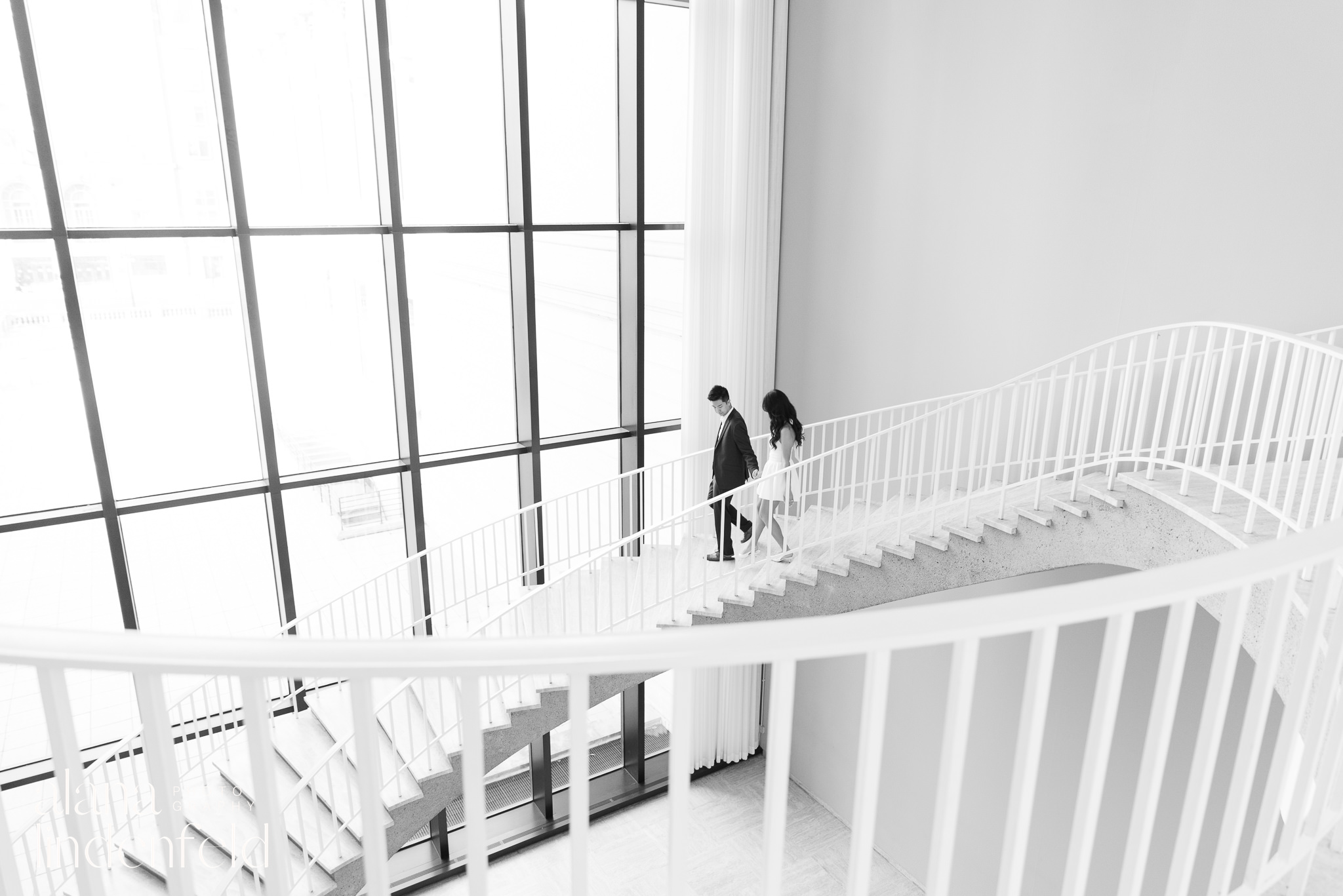 Couple walking down spiral staircase at Art Institute of Chicago for engagement photos