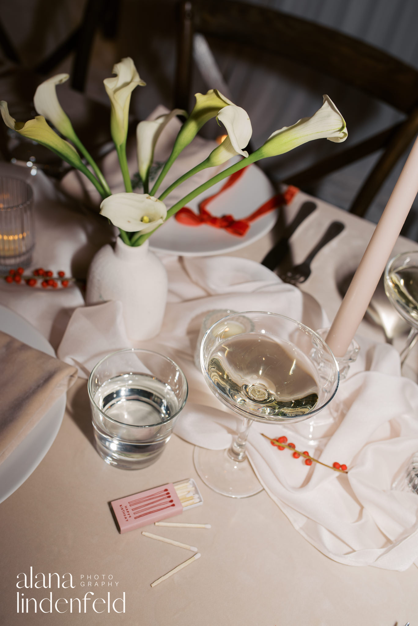 flash photograph of champagne and florals on dinner table 