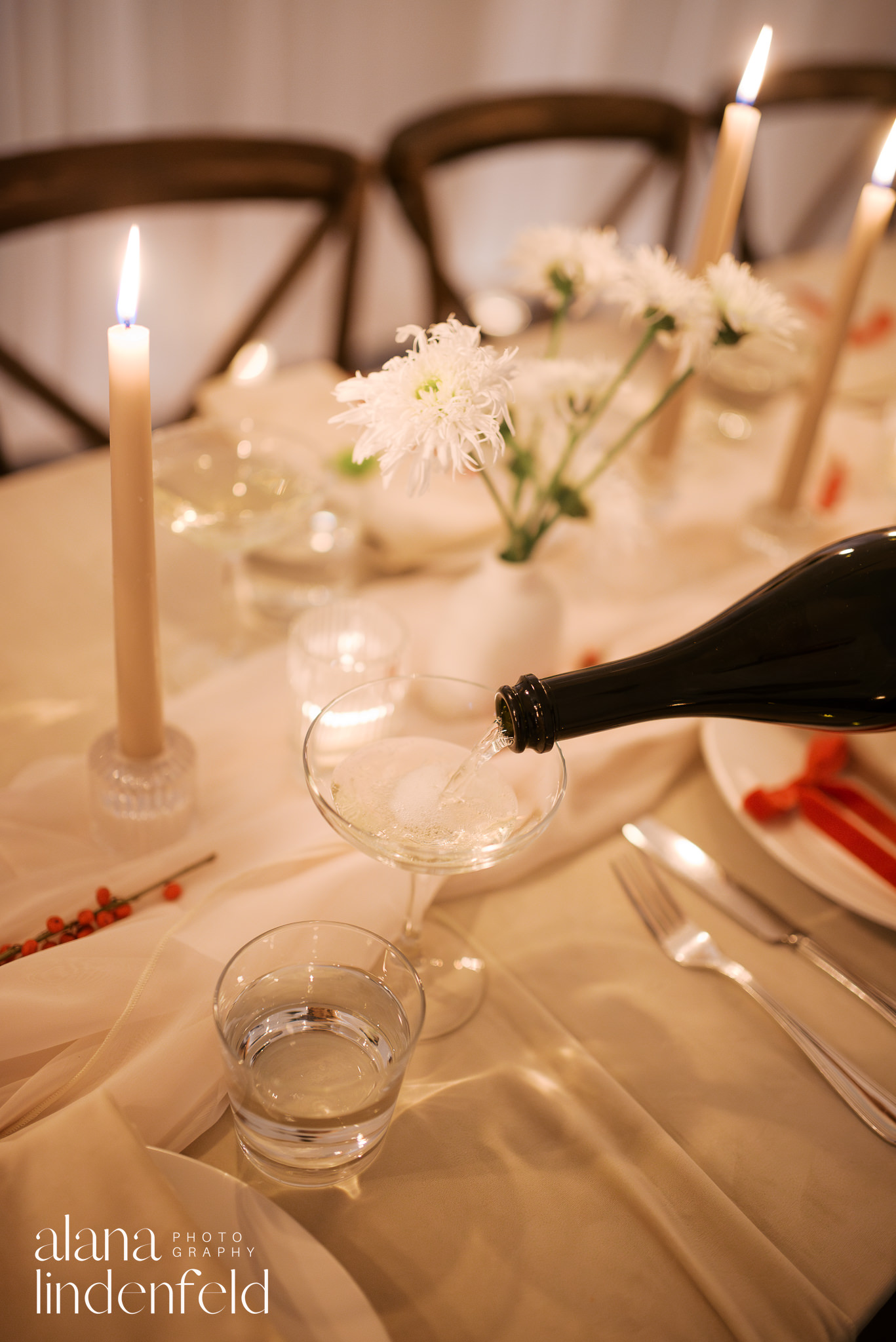 champagne pour on candlelit dinner table with cream and bone colors 