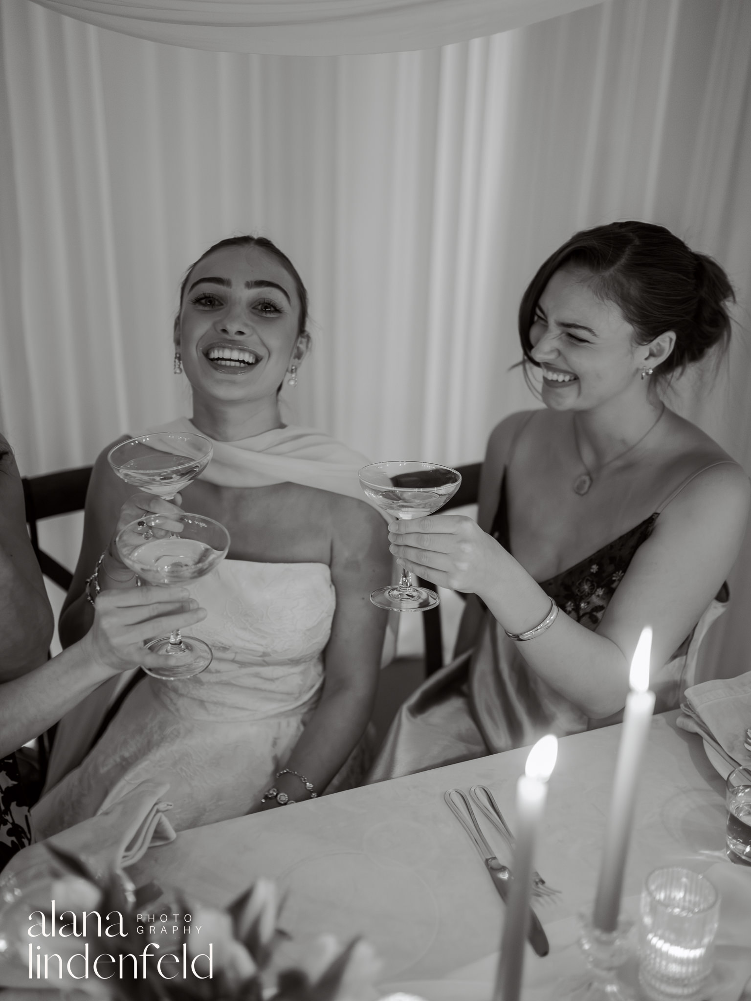 bride and bridesmad toasting at dinner table 