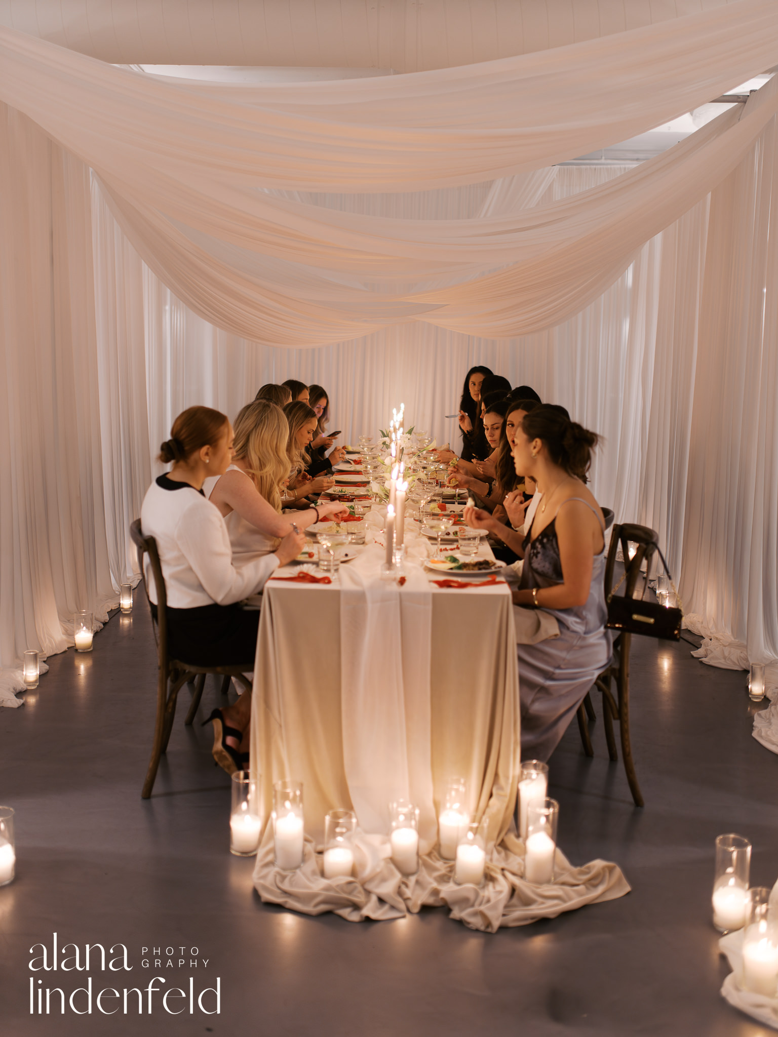 group of women at candlelit dinner table at room 1520 winter reception 