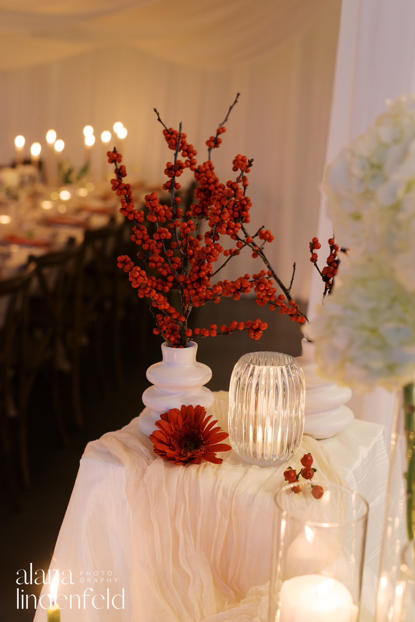 red winter berries in vase at winter dinner reception