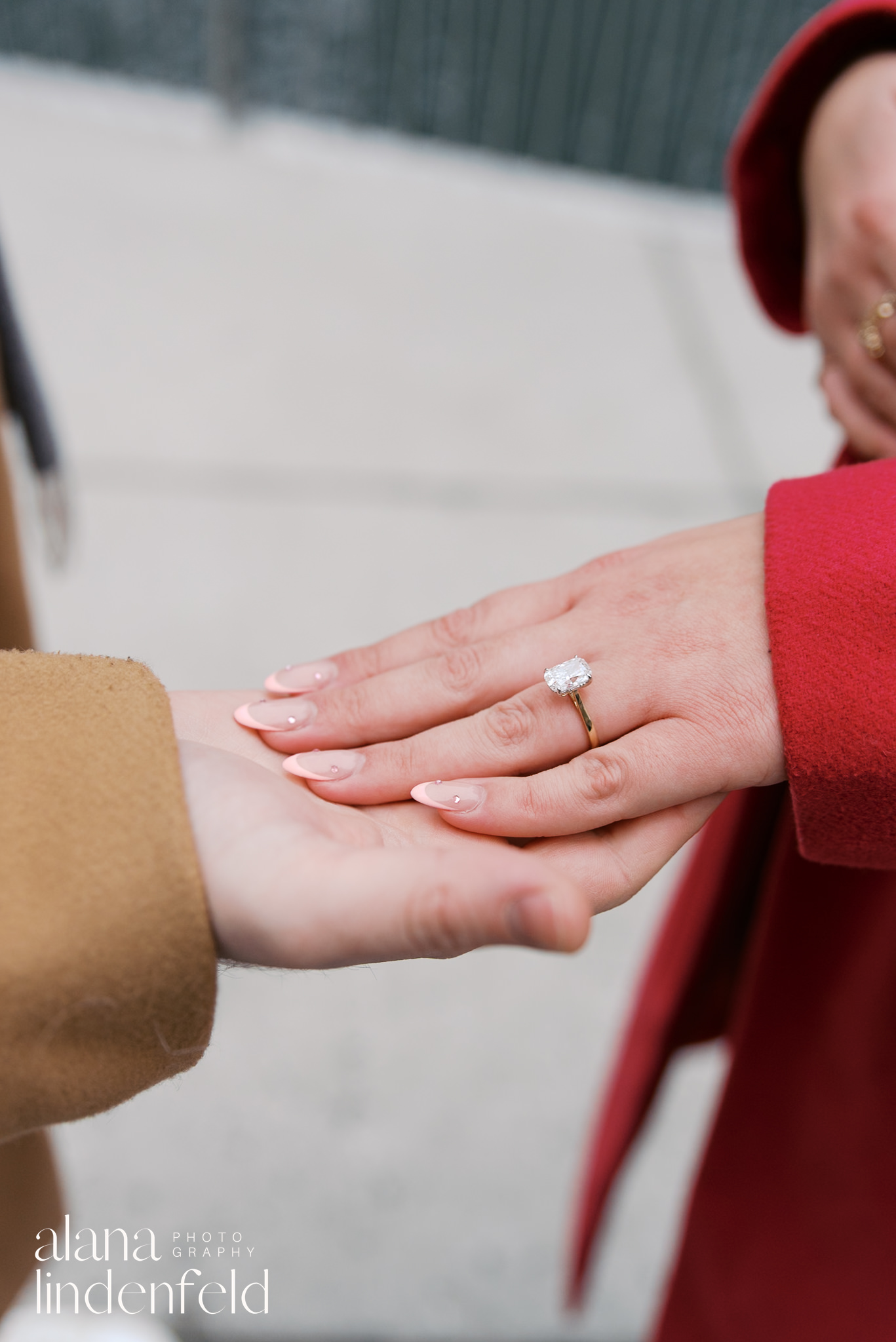 Man holding woman's hand with engagement ring on