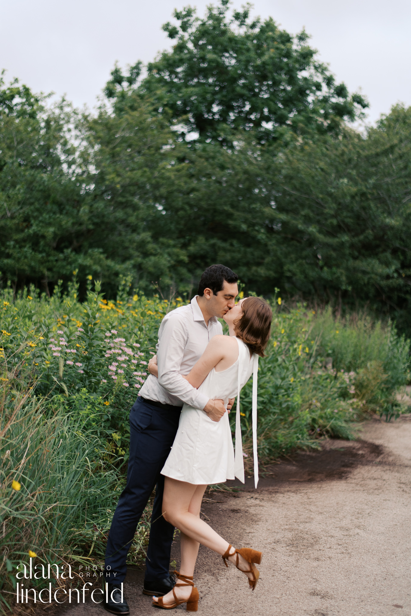 couple in formal wear kissing at Peggy Notebart Nature center for engagement photos