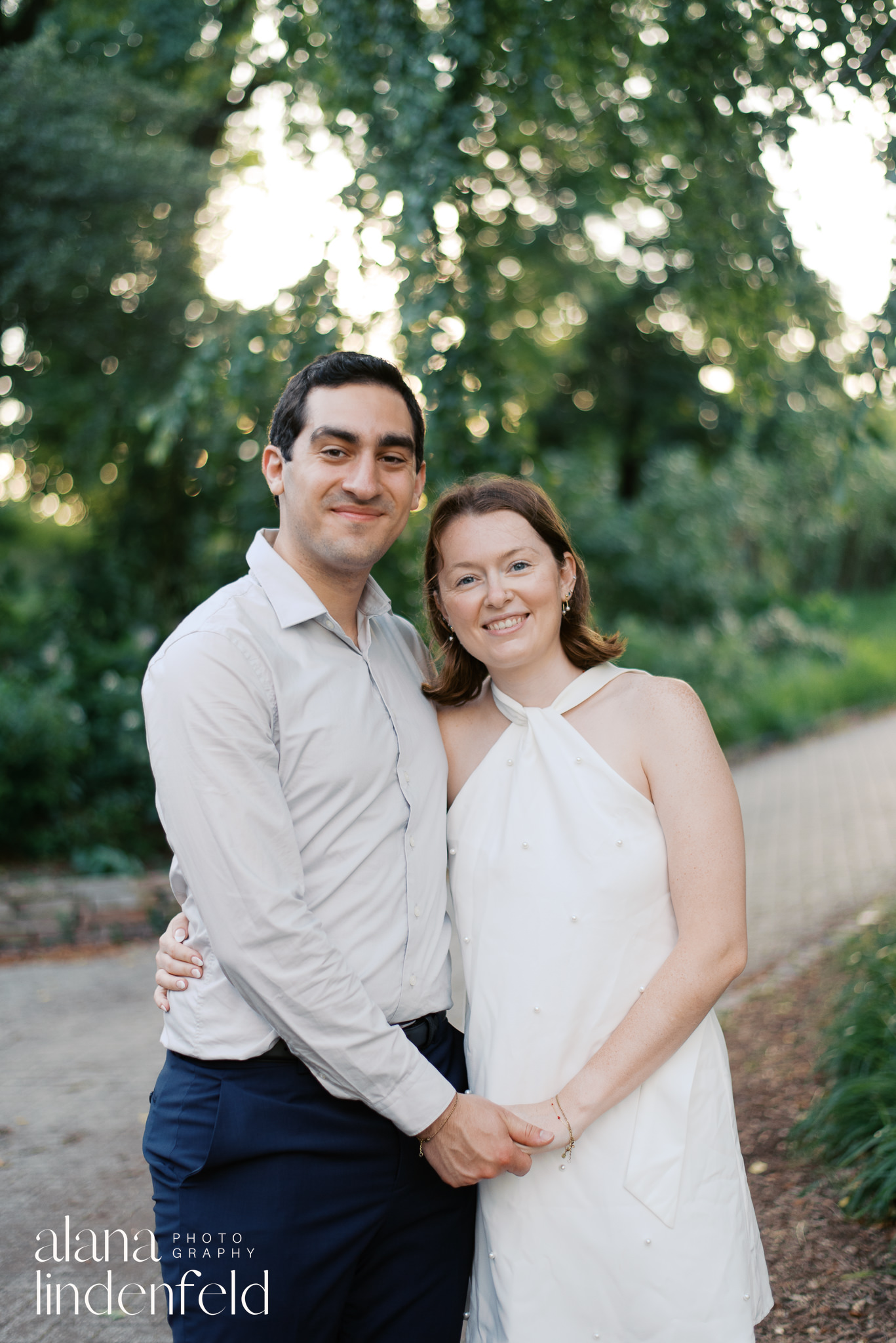 couple smiling and holding hands for engagement photos at North Pond in Lincoln Park, Chicago