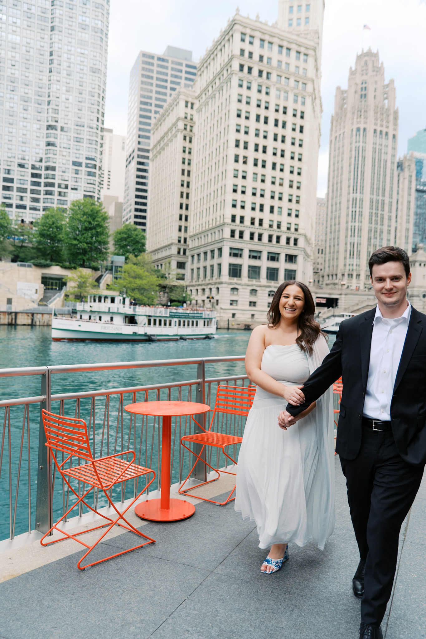 couple holding hands on Chicago Riverwalk engagement pictures in summer