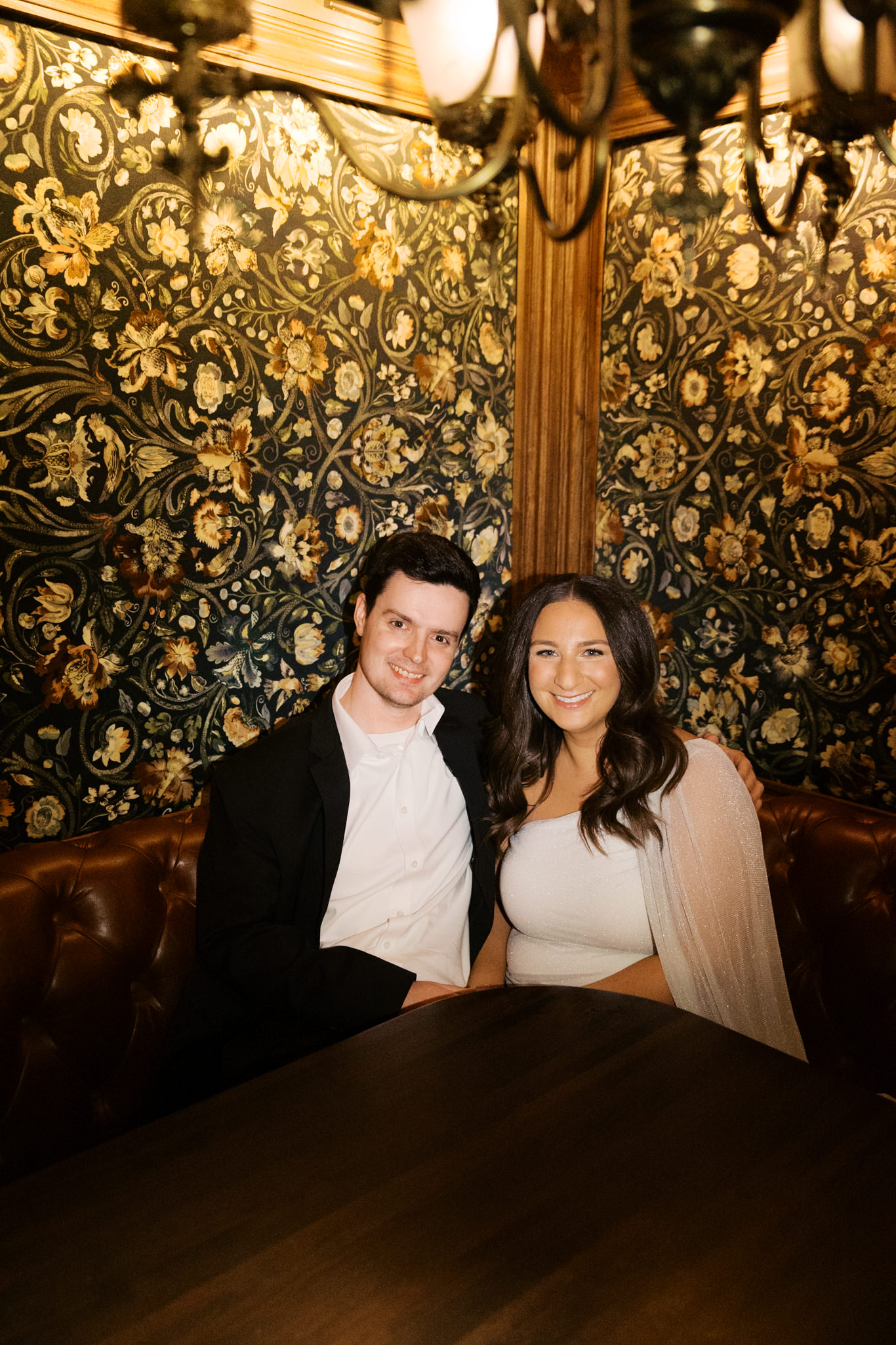 couple in a booth at Gilt Bar for engagement photos 